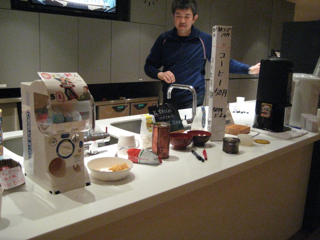 オーケストラホワイエのキッチンと団員さんの写真。