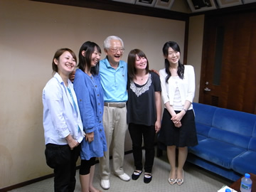 秋山さんと学生さんたちが記念撮影をしている様子の写真。