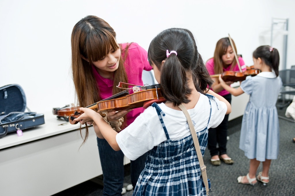 楽器体験でヴァイオリンを持っている女の子の写真