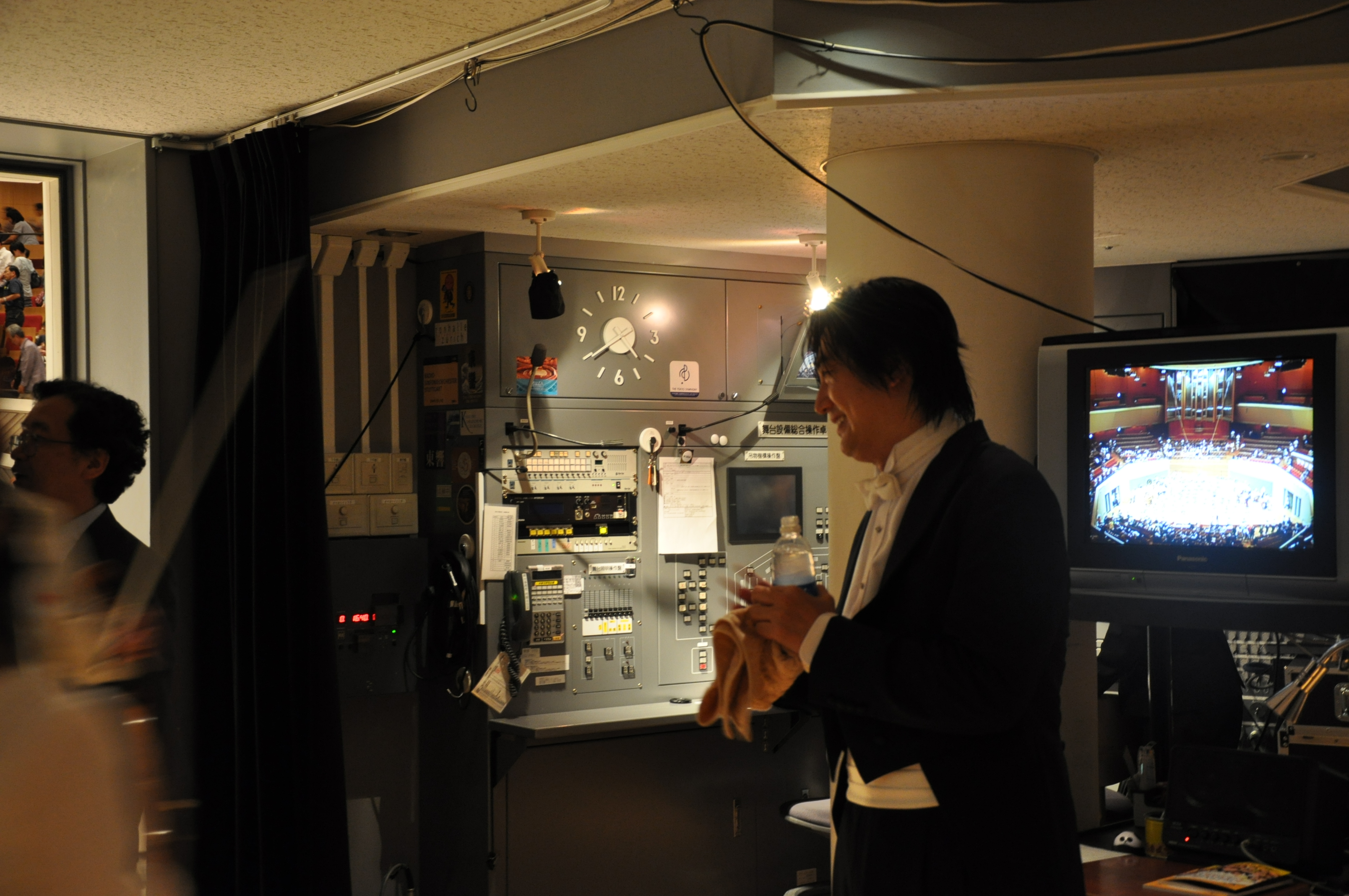 下手袖にて楽団員さんに声をかけるマエストロの様子。マエス
トロの後ろには舞台操作盤が写っている。