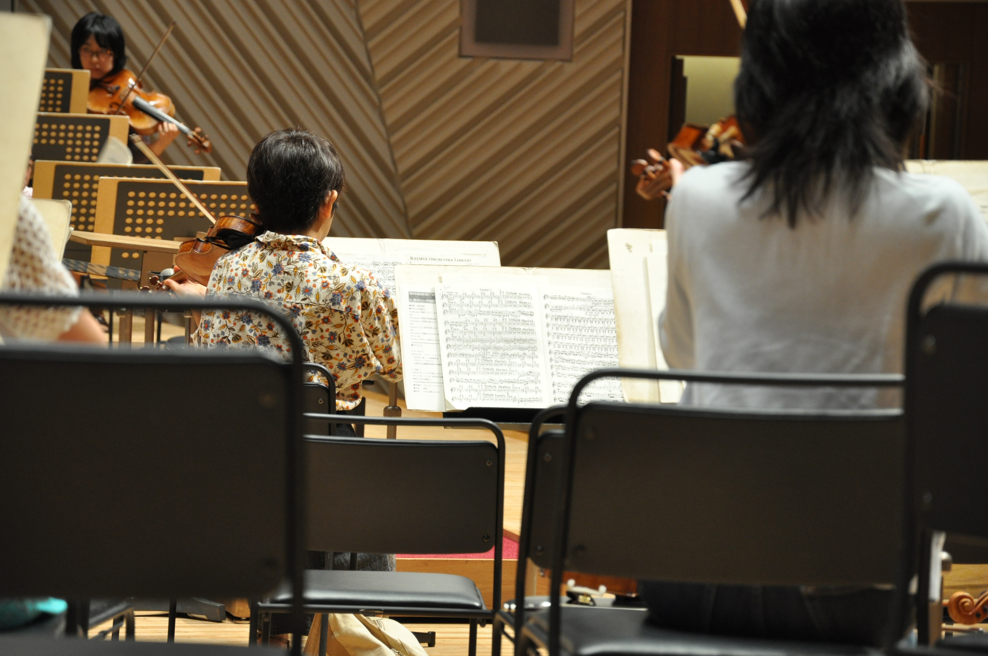 リハーサルをしている様子を後ろから写した2人ほどが写ったアップの写真。