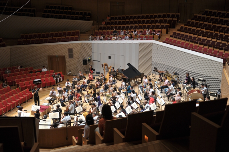 舞台後方上手寄りからステージを移した写真。オーケストラがリハーサルをしている。