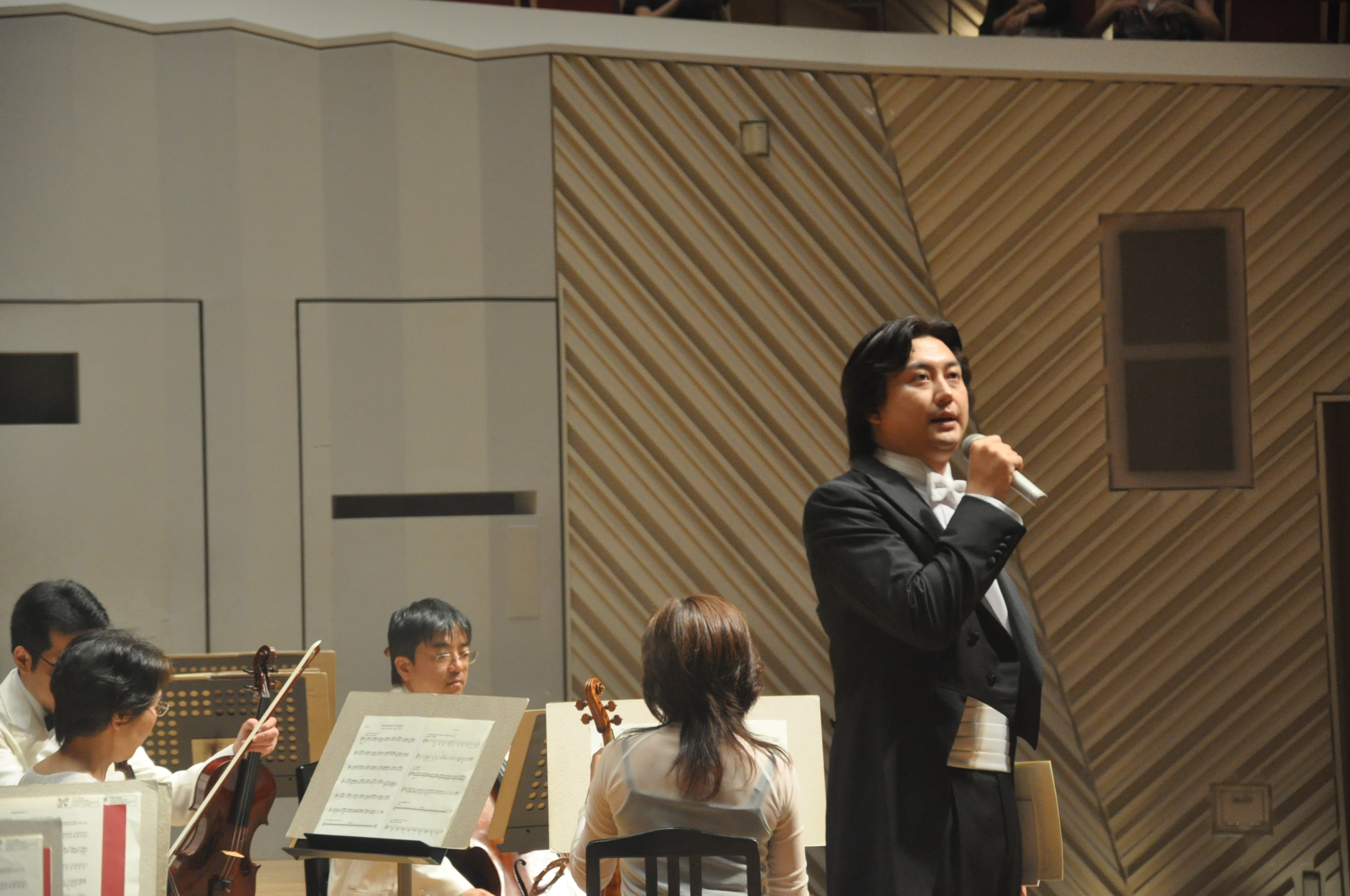 プレトークの様子。右手にマイクを持ち、ステージ上でお話を
しているマエストロ。