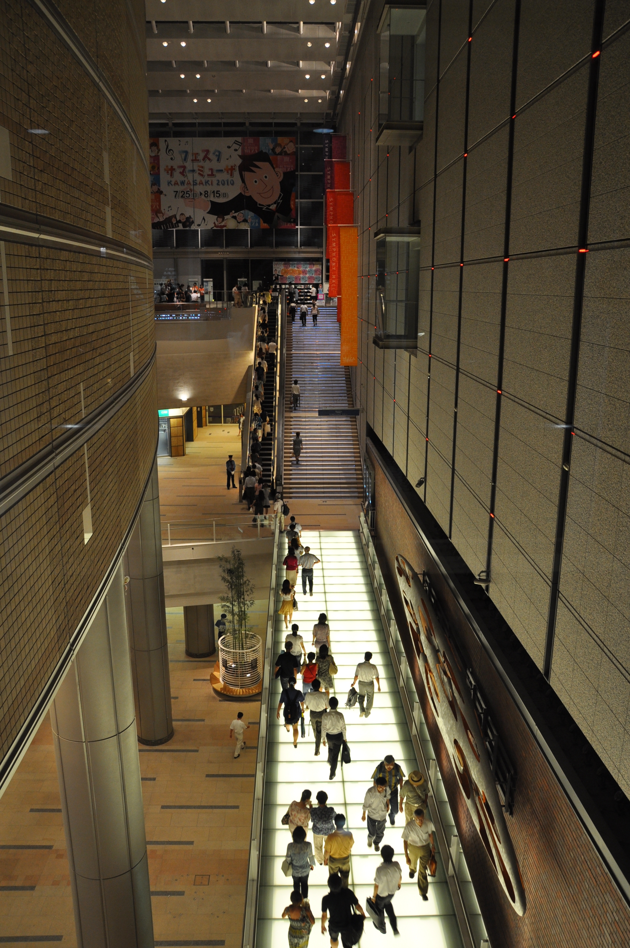 光のブリッジを渡ってホールへ向かうお客様を上からとらえた写真。