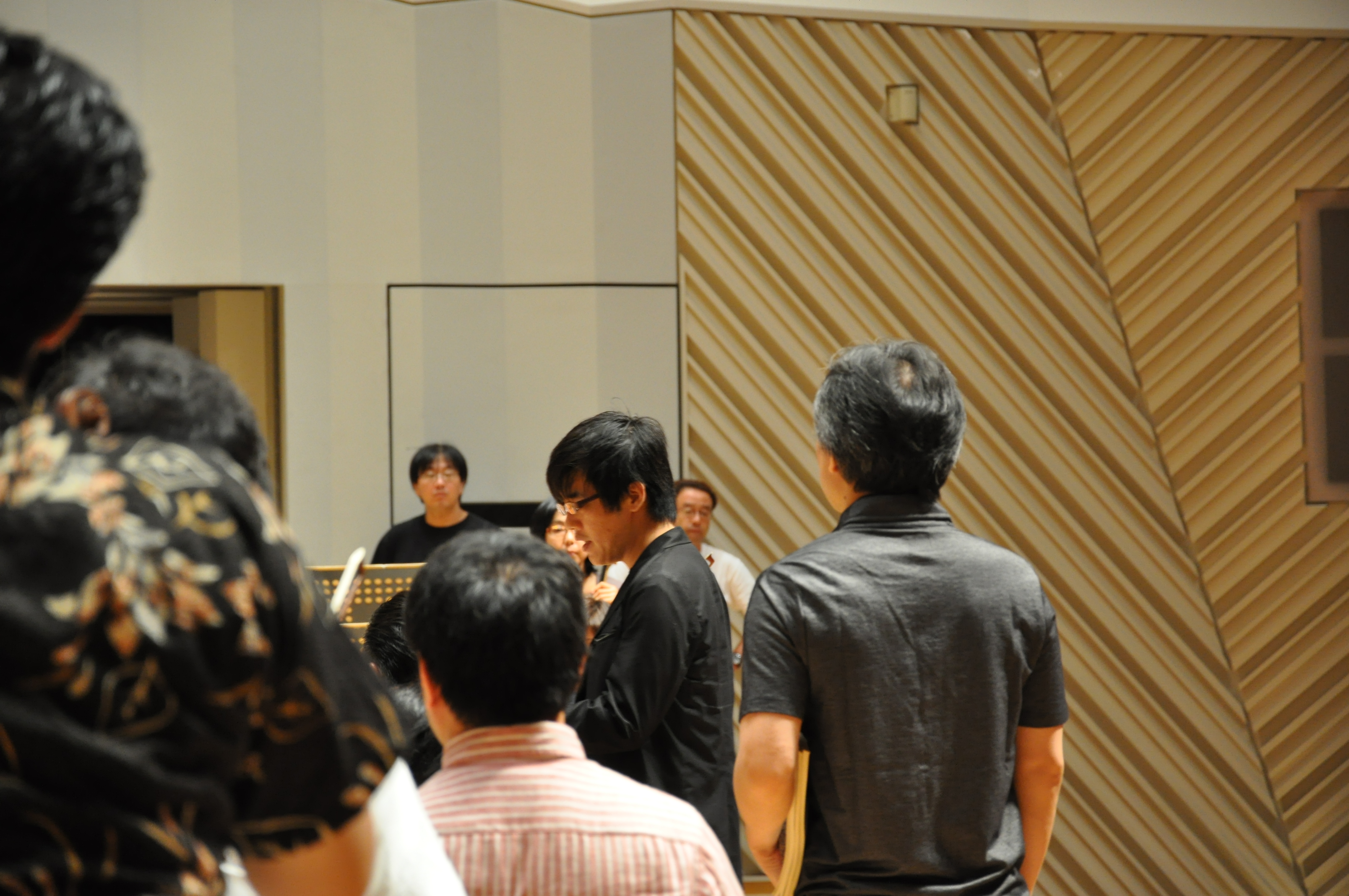 スタッフがステージ前方でオーケストラの方に向かって説明している様子。