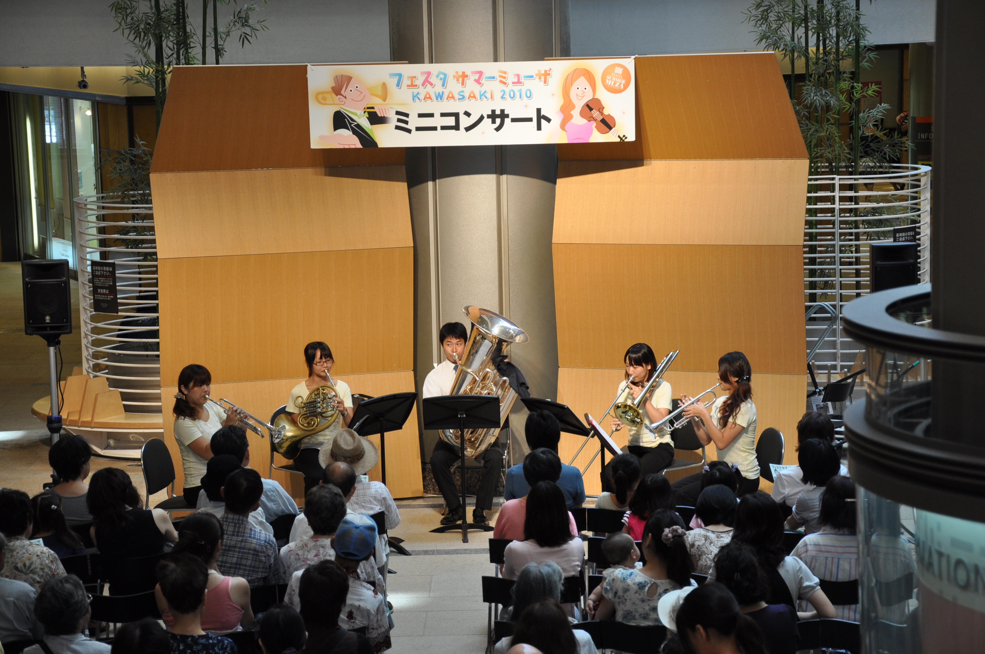 左、下手から、トランペット、ホルン、チューバ、トロンボーン、トランペットのアンサンブルが演奏している写真。