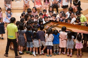 ピアノの周りに集まる子どもたち