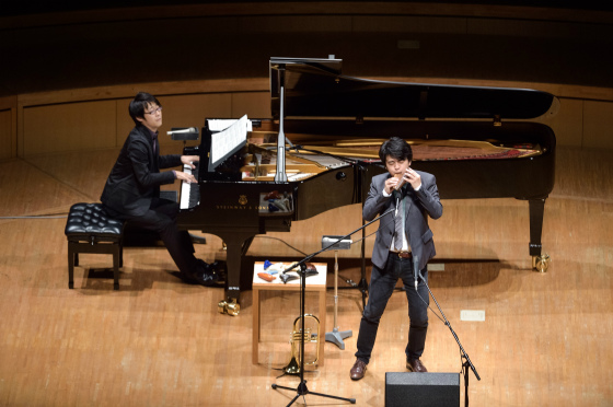 〔写真〕舞台全体を前方から撮影。茨木さんの様子をうかがいながらピアノを弾く森悠也さん。