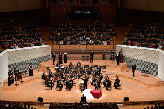 【写真】2幕舞踏会のシーン。オーケストラを囲むように歌手が立ち、舞台全体を使って演技しています。