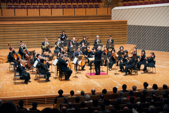 ホールステージ中央で演奏する、東京交響楽団のメンバーと指揮者の鈴木秀美氏。