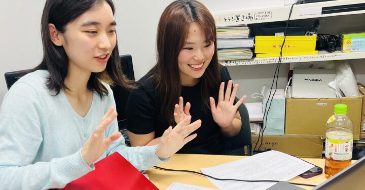 リトルミューザ説明会中のアドバイザー2人。パソコンに向かい笑顔で手を降っている。