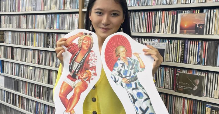 夏祭りの装いのバッハとモーツァルトのイラストを手に持つ服部百音。