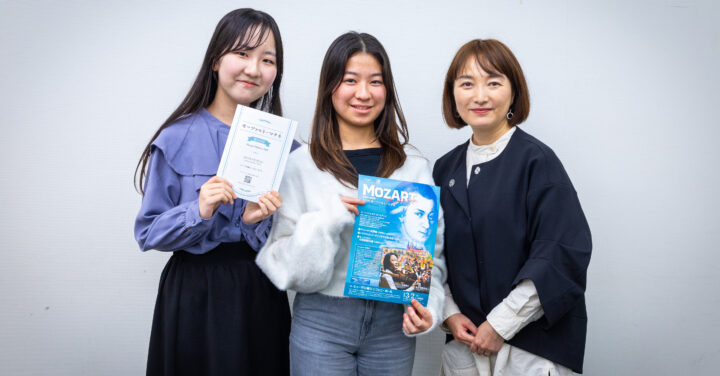 受講生2人と飯田さんの集合写真。受講生達は公演チラシとプログラムをそれぞれ持っている。