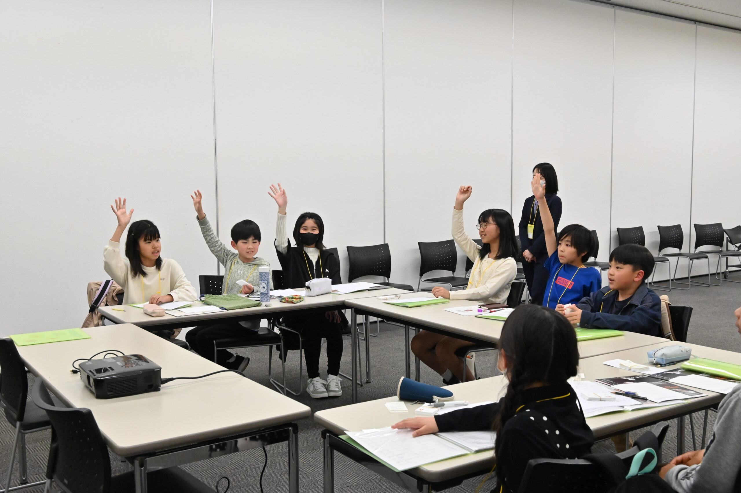9人中5人が肘を伸ばして高く手を挙げている。