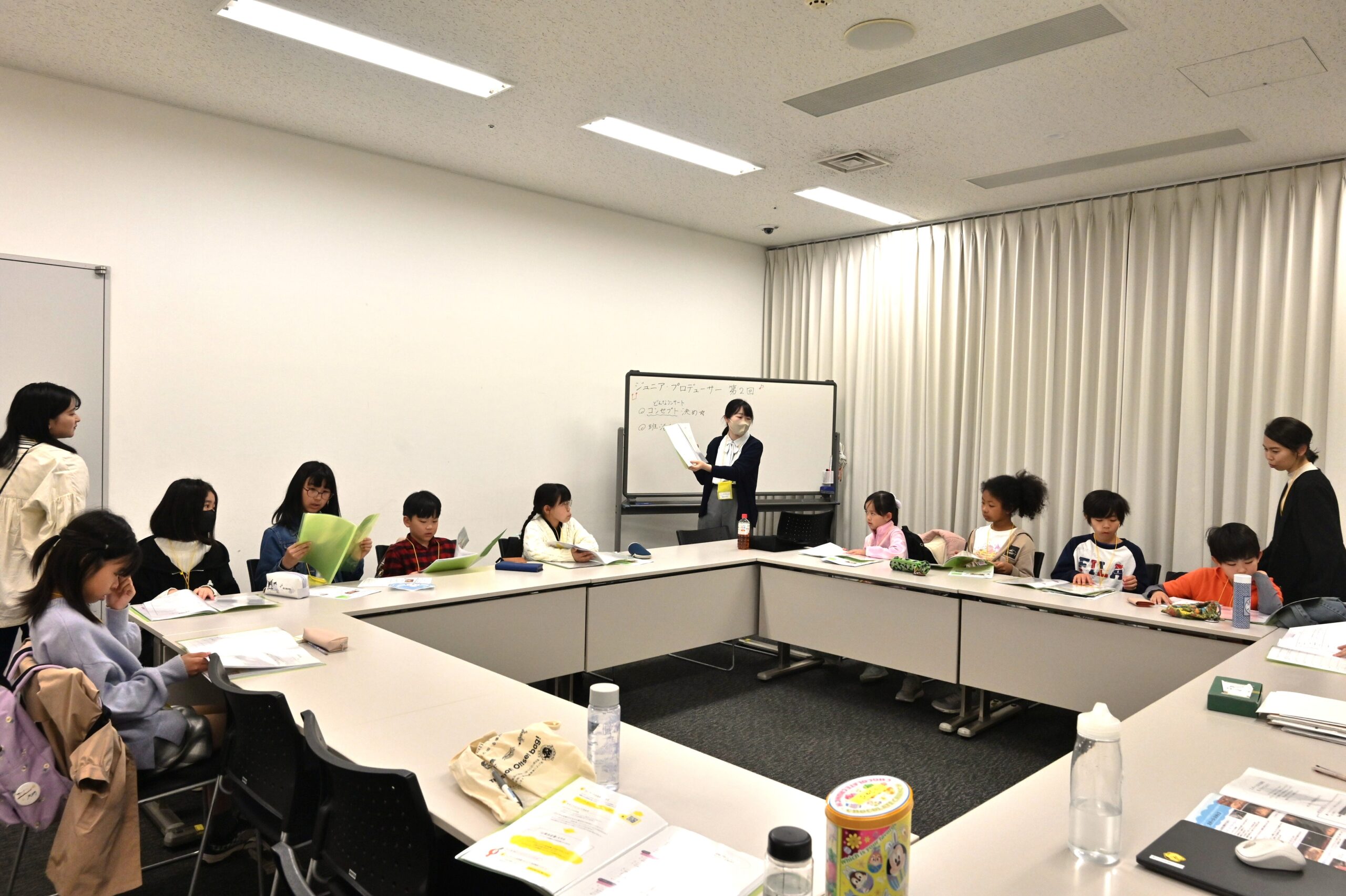 会議室の机に資料を広げて見ているジュニア・プロデューサーたち