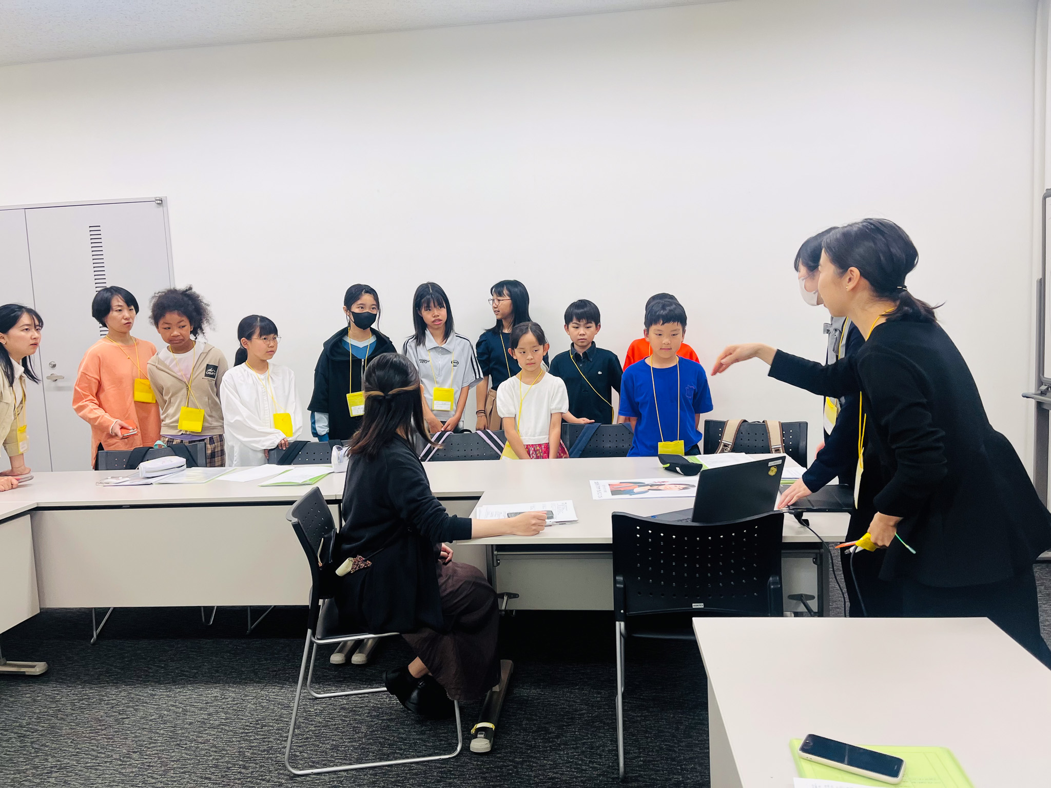壁沿いに2列に並び、パソコンの方を見ているジュニア・プロデューサーたちの写真。大人スタッフが周りでジュニア・プロデューサーたちを見ている。