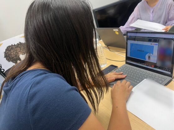 大学生アドバイザーが「質疑応答」と書かれたパソコン画面に向かっている後ろ姿の写真