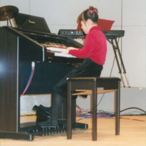 電子オルガンを弾く9歳の澤さんの写真。