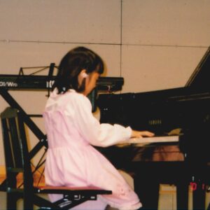 グランドピアノを弾く7歳の澤さん。